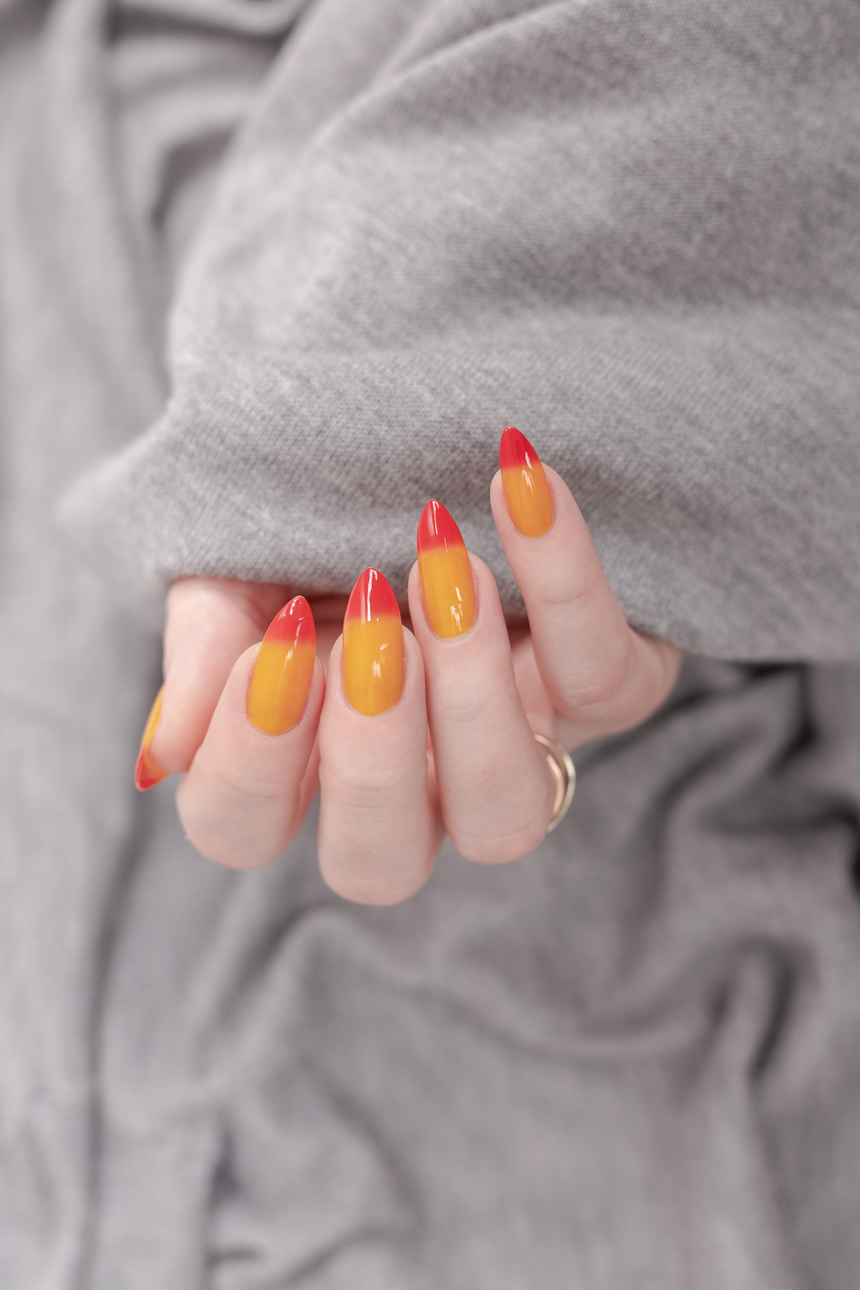 Female hand with long nails and yellow, orange and red gradient manicure